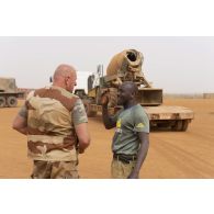 Un soldat du 515e régiment du train (RT) se coordonne avec un chauffeur de poids lourd civil à Gao, au Mali.