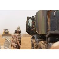 Un soldat du 515e régiment du train (RT) se coordonne avec le chauffeur d'un camion ravitailleur pétrolier de l'avant à capacité étendue (CARAPACE) du Service de l'énergie opérationnelle (SEO) à Gao, au Mali.