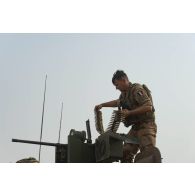 Un para du 3e régiment parachutiste d'infanterie de marine (RPIMa) approvisionne la mitrailleuse Browning 12,7 mm de son véhicule de l'avant blindé (VAB) sur le pas de tir de Ouallam, au Niger.