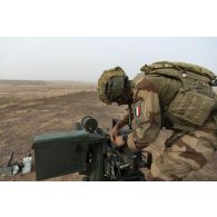 Un para du 3e régiment parachutiste d'infanterie de marine (RPIMa) approvisionne la mitrailleuse Browning 12,7 mm de son véhicule de l'avant blindé (VAB) sur le pas de tir de Ouallam, au Niger.