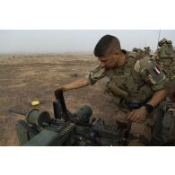 Un para du 3e régiment parachutiste d'infanterie de marine (RPIMa) approvisionne la mitrailleuse Browning 12,7 mm de son véhicule de l'avant blindé (VAB) sur le pas de tir de Ouallam, au Niger.