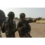 L'adjudant Arnaud du 3e régiment parachutiste d'infanterie de marine (RPIMa) se coordonne avec des gendarmes nigériens pour le ratissage d'une zone boisée dans le secteur de Ouallam, au Niger.