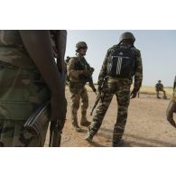 L'adjudant Arnaud du 3e régiment parachutiste d'infanterie de marine (RPIMa) se coordonne avec des gendarmes nigériens pour le ratissage d'une zone boisée dans le secteur de Ouallam, au Niger.