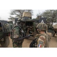 Un sapeur du 17e régiment du génie parachutiste (RGP) se coordonne avec un gendarme nigérien pour l'analyse du contenu d'un téléphone portable saisi dans le secteur de Ouallam, au Niger.