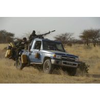 Des gendarmes nigériens progressent à bord de leur pick-up dans le secteur de Ouallam, au Niger.