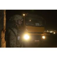 Un soldat estonien du bataillon scout (Scoutspataljon) contrôle l'arrivée nocturne d'un camion-semi remorque sur la plateforme de Gao, au Mali.