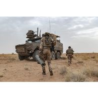 Des marsouins du 21e régiment d'infanterie de marine (RIMa) s'apprêtent à embarquer à bord de leur véhicule blindé multi-rôles (VBMR) Griffon au sommet d'un mouvement de terrain à Gao, au Mali.