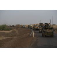 Un véhicule de l'avant blindé (VAB) et un véhicule blindé multi-rôles (VBMR) Griffon sécurisent la progression d'un convoi sur un axe routier de Gao, au Mali.