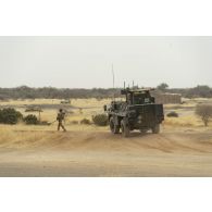 Un légionnaire du 1er régiment étranger de génie (REG) inspecte un point de passage sous la protection d'un véhicule de l'avant blindé (VAB) sur la piste de Ménaka, au Mali.