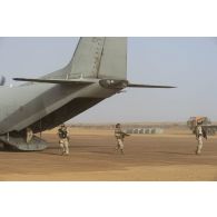 Des soldats italiens se déploient pour sécuriser le chargement d'un avion cargo Alenia C-27 Spartan II de l'Aeronautica Militare sur la base de Ménaka, au Mali.