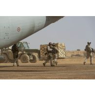 Des soldats italiens se déploient pour sécuriser le chargement d'un avion cargo Alenia C-27 Spartan II de l'Aeronautica Militare sur la base de Ménaka, au Mali.