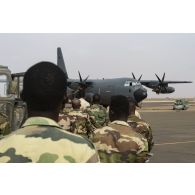 Des parachutistes nigériens embarquent à bord d'un avion C-130 H-30 Hercules sur la base de Niamey, au Niger.