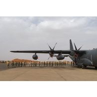 Des parachutistes nigériens embarquent à bord d'un avion C-130 H-30 Hercules sur la base de Niamey, au Niger.