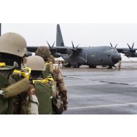 Des parachutistes nigériens embarquent à bord d'un avion C-130 H-30 Hercules sur la base de Niamey, au Niger.