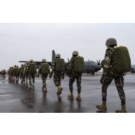 Des parachutistes nigériens embarquent à bord d'un avion C-130 H-30 Hercules sur la base de Niamey, au Niger.