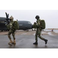 Des parachutistes nigériens embarquent à bord d'un avion C-130 H-30 Hercules sur la base de Niamey, au Niger.