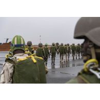 Des parachutistes nigériens embarquent à bord d'un avion C-130 H-30 Hercules sur la base de Niamey, au Niger.