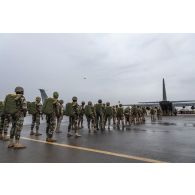 Des parachutistes nigériens embarquent à bord d'un avion C-130 H-30 Hercules sur la base de Niamey, au Niger.