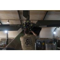 Un mécanicien aéronautique démonte les jeux d'amortisseurs du rotor anticouple d'un hélicoptère Caïman NH-90 à Gao, au Mali.