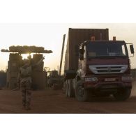 Un soldat guide la circulation d'un camion semi-remorque à son arrivée sur la base de Gossi, au Mali.