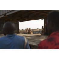 Un soldat guide le chargement d'un container sur un camion semi-remorque à Gossi, au Mali.