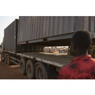 Un soldat guide le chargement d'un container sur un camion semi-remorque à Gossi, au Mali.