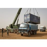Une grue automotrice LTM 1055 décharge un container depuis un camion semi-remorque à Gao, au Mali.