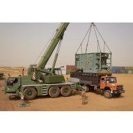 Une grue automotrice LTM 1055 décharge un container depuis un camion semi-remorque à Gao, au Mali.