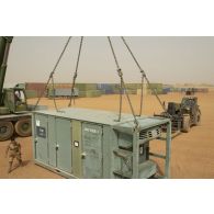 Une grue automotrice LTM 1055 et un chariot élévateur lourd (CEL) déchargent un container à Gao, au Mali.