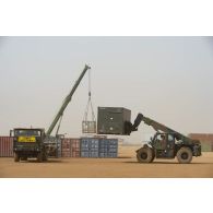 Une grue automotrice LTM 1055 et un chariot élévateur lourd (CEL) déchargent des containers à Gao, au Mali.