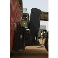 Une grue automotrice LTM 1055 et un chariot élévateur lourd (CEL) chargent des containers à Gao, au Mali.