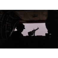 Un membre opérationnel de soute (MOS) britannique sécurise le périmètre en soute d'un hélicoptère Chinook CH-47 au-dessus du secteur de Ouallam, au Niger.