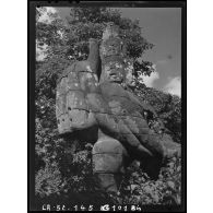 Géant polycéphale et à bras multiples étreignant la queue du Naga, formant balustrade devant la porte dite des Morts de l'enceinte Est du Bayon.