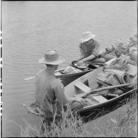 Sur les sampans, des tirailleurs participant à l'opération Tourbillon VII préparent le repas du soir. [description provisoire]