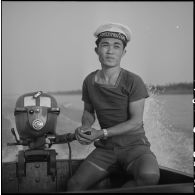 Un barreur de la marine nationale laotienne sur une vedette moto.