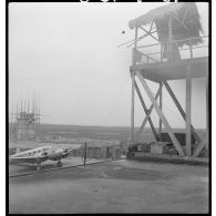 Un avion transporteur au pied d’une tour de garde de l’aérodrome de Hué.