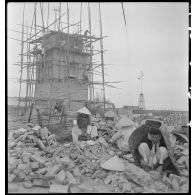 Des coolies travaillant à la construction d’une tour de garde de l’aérodrome de Hué.