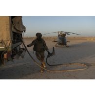 Un soldat du Service de l'énergie opérationnelle (SEO) ravitaille un hélicoptère Gazelle SA-342M en carburant dans le secteur du Liptako, au Niger.