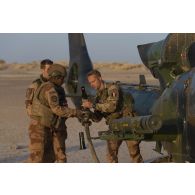 Un pilote du 5e régiment d'hélicoptères de combat (RHC) ravitaille un hélicoptère Gazelle SA-342M1 en carburant dans le secteur du Liptako, au Niger.