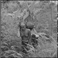 Montagnards portant des hottes sur une piste de forêt entre Vientiane et Xieng Khouang.
