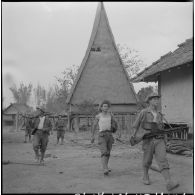 Une patrouille du 28e bataillon vietnamien traversant un village dans la région de Kon Tum.