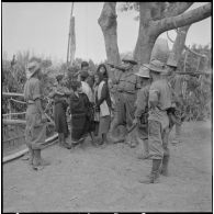 Des éléments du 28e bataillon vietnamien (28e BVN) stationnés dans un village de la région de Kontum discutent avec des Montagnards.