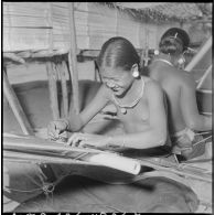 Tissage du coton par des femmes Jaraï à l'intérieur d'une habitation traditionnelle sur pilotis.