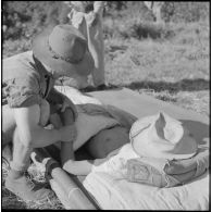 Le médecin-lieutenant Guiraud examine un chasseur laotien blessé par l'explosion d'une mine au cours de l’opération Frimaire dans la province de Xieng Khouang.
