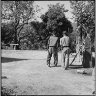 Un prisonnier laotien entravé aux pieds se déplace aux côtés d'une sentinelle, en marge de l'opération Frimaire dans la province de Xieng Khouang.
