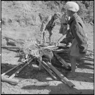  Au cantonnement, un feu a été allumé par des soldats de l'Armée nationale laotienne pour faire cuire un cochon.