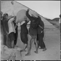 Transport des sacs de sel jusqu'aux jonques amarrées au port de Hon Khoi.