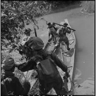 Passage d'une rivière par des soldats du 2e bataillon de chasseurs laotiens (2e BCL) sur des pirogues récupérées.