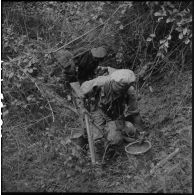 Découverte d'un dépôt de riz sous des branchages lors d'une fouille du 2e bataillon de chasseurs laotiens.