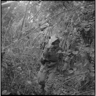Un chasseur du 2e bataillon de chasseurs laotiens (2e BCL) progresse avec précaution au milieu de lianes épineuses.